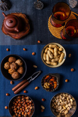 Food themed still life with crockery, various nuts and tea. Flat lay. Top view.