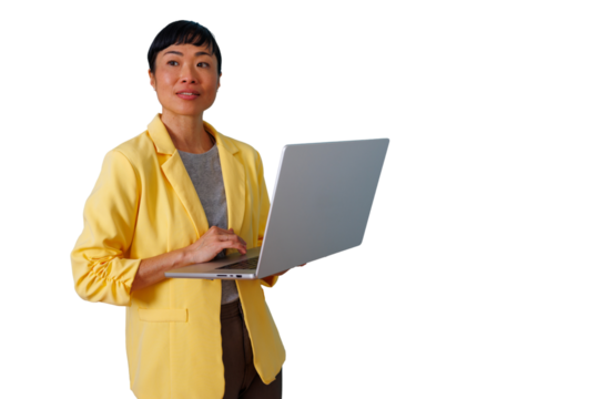 Asian businesswoman in yellow blazer standing, using laptop, focused on technology and professional work on transparent background