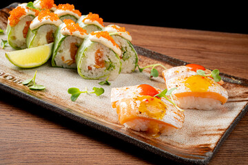 Sushi rolls filled with fresh ingredients sit beside beautifully crafted nigiri on a wooden table