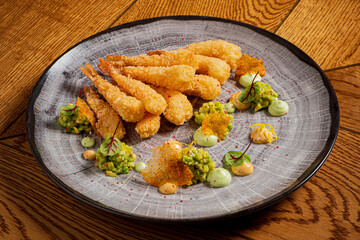 Delicious crispy shrimp accompanied by colorful sauces and garnishes on a beautiful wooden table