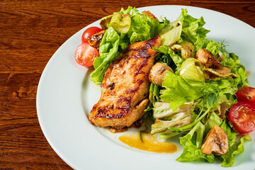 Grilled chicken breast on fresh lettuce and veggies, highlighting healthy eating