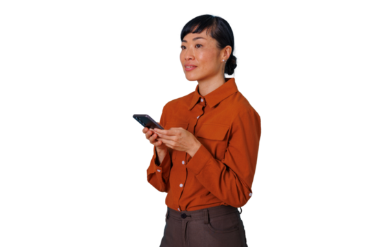 East asian woman standing, holding smartphone, wearing casual business attire, looking away on transparent background