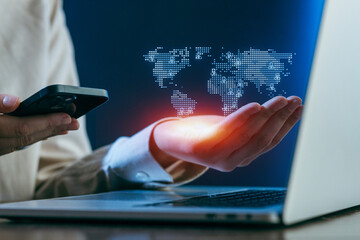 Exploring digital connectivity with a smartphone and laptop while visualizing a world map