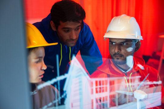 Modern construction and engineering Team Collaborating on Futuristic Holographic Interface Analyzing. Holographic Technology for Innovative house Development Planning