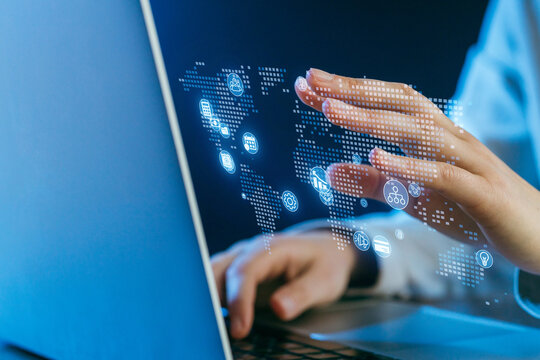 Hands interacting with digital interface above laptop in a tech workspace focusing on global connectivity - Powered by Adobe