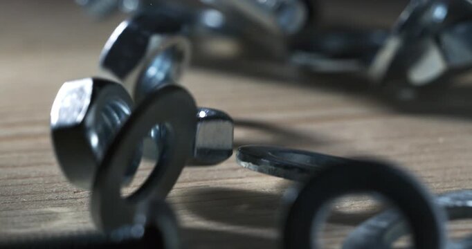 Slow Motion Macro Shot Of Metal Washers, Nuts And Bolts Scattering Across A Wooden Surface With Sharp Reflections, Industrial Texture And Precise Mechanical Motion At 1000 Fps. Concept Of Engineering 