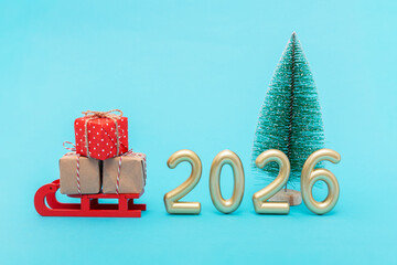 Christmas gifts on sleigh beside golden 2026 and small tree. Symbol of holiday celebration, joy and new year spirit.