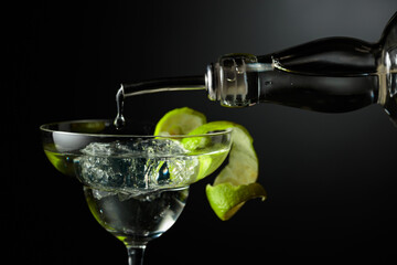 Vodka or gin is poured into a glass with ice.