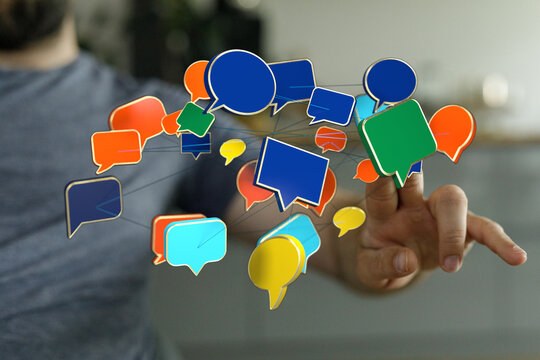 Concept image of a man's hand touching connected speech bubbles, representing online messaging and communicatio - Powered by Adobe
