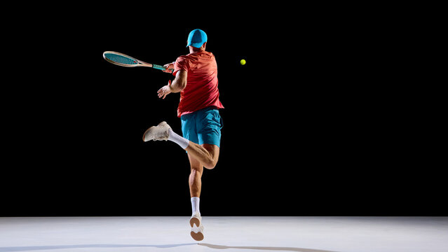 Male tennis player hitting ball midair with focus and agility. Concept of science and motion study, biomechanics, research visuals, energy flow, and body precision in movement.