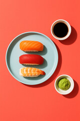 Top view of sushi flat lay on coral colour background