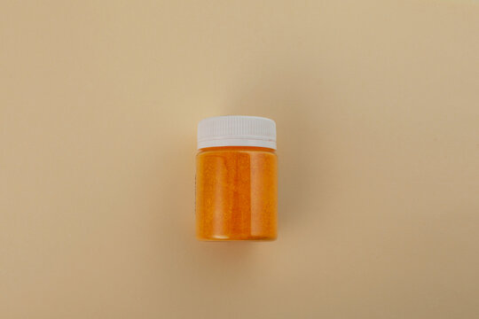 Tartrazine powder in plastic jar. Food dye CI 19140 or FD&C. Food additive E102. Tartrazine is a synthetic lemon yellow azo dye
