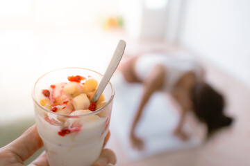 Woman in push-up position with yogurt parfait in hand