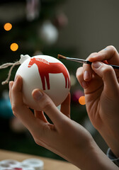 Hand-Painted Red Dala Horse on Matte Ceramic Christmas Bauble — Scandinavian Minimalist Craft Close-Up