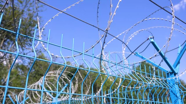 Barbed wire on the fence against a sky background