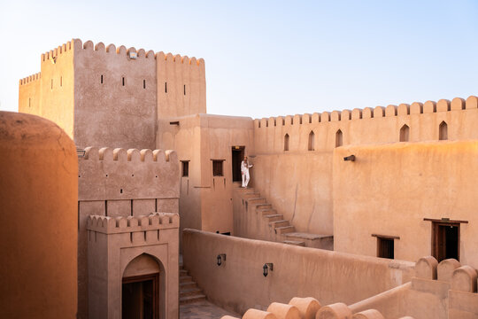 Woman walking down steps inside the historic nizwa fort in oman