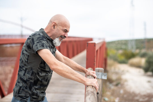 A 65-year-old man warms up and stretches his muscles before going for a run