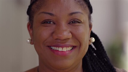 Close up portrait of African American woman smiling warmly, natural expression conveying confidence, friendliness, and authentic joy in soft daylight - Powered by Adobe