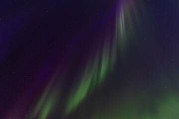 Ethereal glow of green and subtle pink Northern Lights streaks across the deep blue-purple expanse...