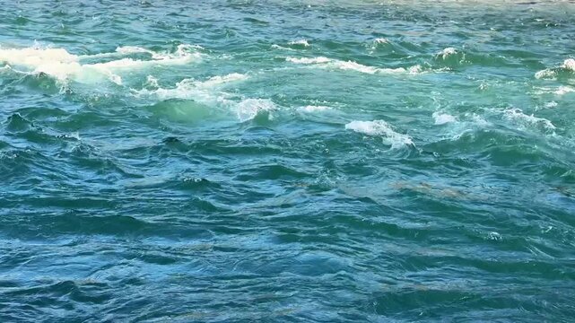Fast river water flowing quickly with bright white foamy waves