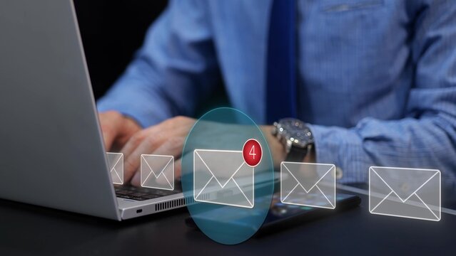 Businessman using laptop with virtual email notification. Digital marketing and client communication concept. Graphic