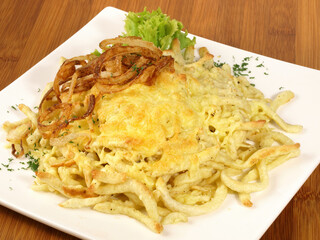 Food - Swabian Noodles with grated Cheese on wooden Background