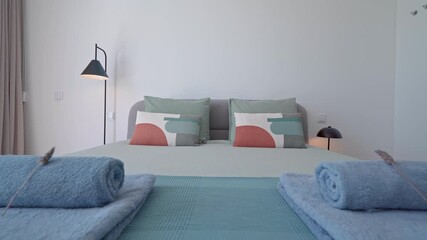 Pristine white towels neatly folded and arranged on crisp bedding, showcasing meticulous housekeeping and welcoming hospitality within modern minimalist hotel room interior