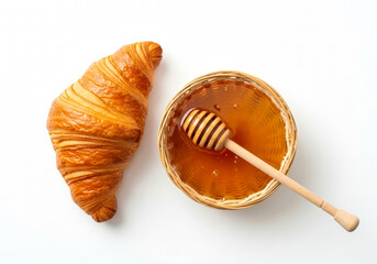 Croissant with honey, dipper in a basket on wooden table, flat lay on a white background
