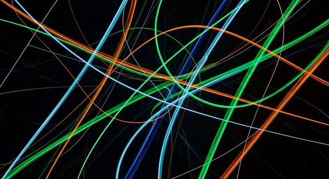 Abstract streaks of colorful light trails in motion, illuminated against a dark background, creating a dynamic and energetic visual effect