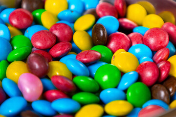 Colorful candy assortment featuring bright blue, yellow, green, red, pink, and brown candies arranged in a bowl for a festive treat at a celebration or gathering