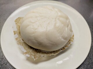 白い皿の上の温かく蒸された中華まん（肉まん・あんまん）日本の冬の味覚