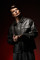 Charming young man embodies modern masculinity with style and confidence in dim lighting