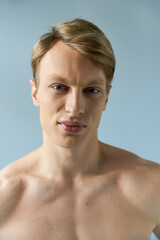 Young man exuding confidence and modern masculinity in a studio setting with soft lighting