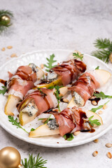 Delicious pear and blue cheese wrapped in hamon served on arugula with a drizzle of balsamic reduction