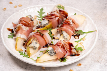 Delicious pear and blue cheese bites wrapped in hamon with arugula and pine nuts
