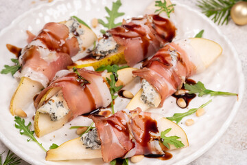 Delicious pear slices topped with blue cheese, hamon, and arugula drizzled with balsamic glaze for a delightful appetizer