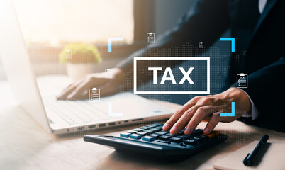 Businessman using calculator and laptop with tax icon overlay, representing tax calculation, financial planning, online accounting, and corporate finance in modern digital environment.