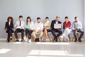 Diverse job candidates, people sitting in office hall on chairs in row, businesspeople waiting for...