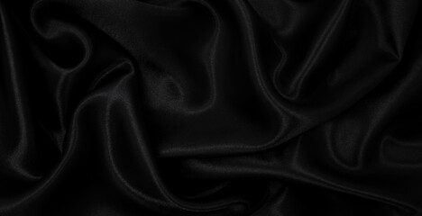 Smooth elegant black silk or satin luxury cloth texture as abstract background. Luxurious background design