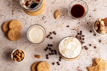 Different types of coffee drinks with cookies on a beige table, top view. Iced coffee, espresso, espresso with milk, brew coffee with almond and whole grain cookies