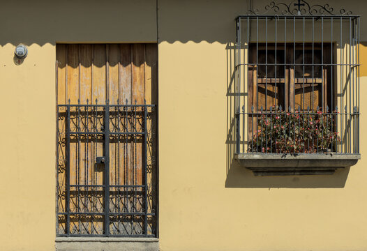 colonial colorful buildings in antigua guatemala detail window door grate gate windows cornice volcano church street travel tourism historic old spanish style architecture - Powered by Adobe