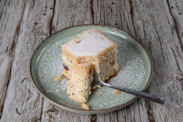 snack with delicious pie with sweet cottage cheese and raisins on a light green ceramic plate on a wooden background