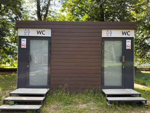 Public space in park with modern restroom for men and women. New restrooms are being installed in city parks to provide comfortable environment. Outdoor urination and gender specific signs