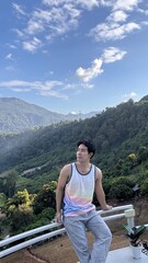 Naklejka premium Handsome Man Relaxing on a Camping Trip with Scenic Green Mountain View