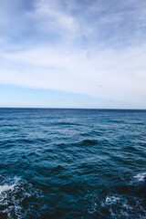 Paisaje del mar azul intenso con horizonte y cielo azul claro con nubes  © Eva