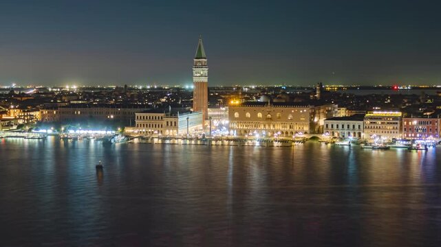 Day to night transition long exposure time lapse aerial of Riva degli Schiavoni, Doge's Palace and busy Venetian Lagoon traffic, Venice, Italy