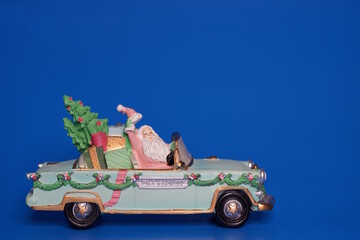 A toy car with Santa Claus and the date 2026 on a blue background. A festive event.