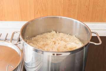 The pot is filled with sauerkraut fermented cabbage, which is submerged in liquid and ready for cooking or heating