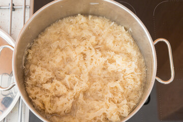 The pot is filled with sauerkraut fermented cabbage, which is submerged in liquid and ready for cooking or heating
