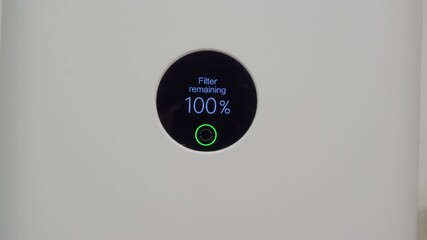 A close-up of a modern air purifier's circular digital display shows "Filter remaining 100%." The reading confirms that the filter is brand new or recently reset after cleaning or replacement.